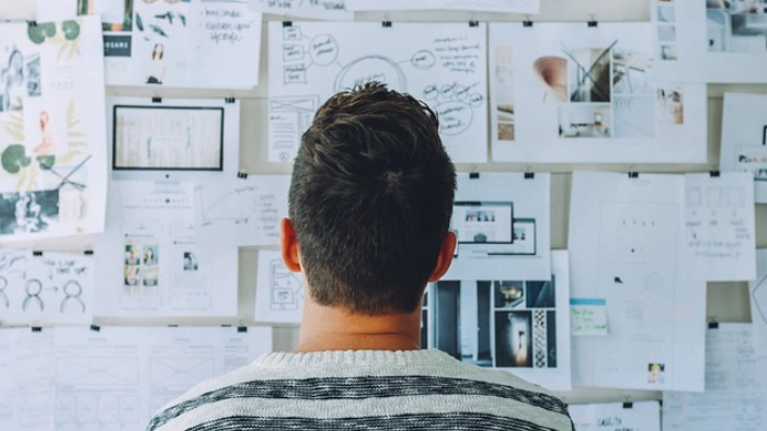 man looking at a plans on a wall